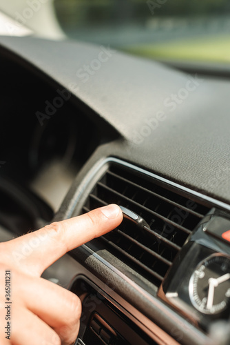Cropped view of man adjusting ventilation system in car