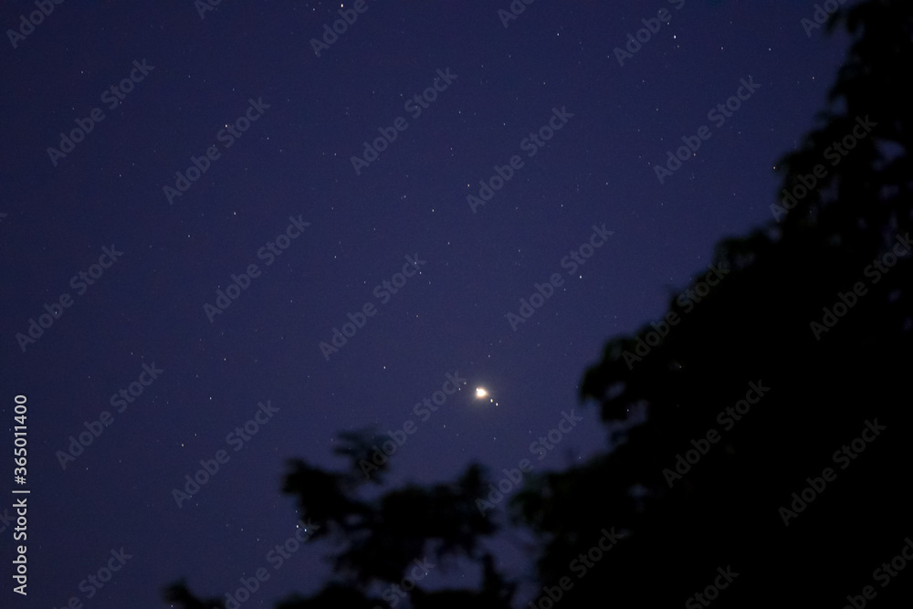 Jupiter and Saturn in the night sky with its four satellites 