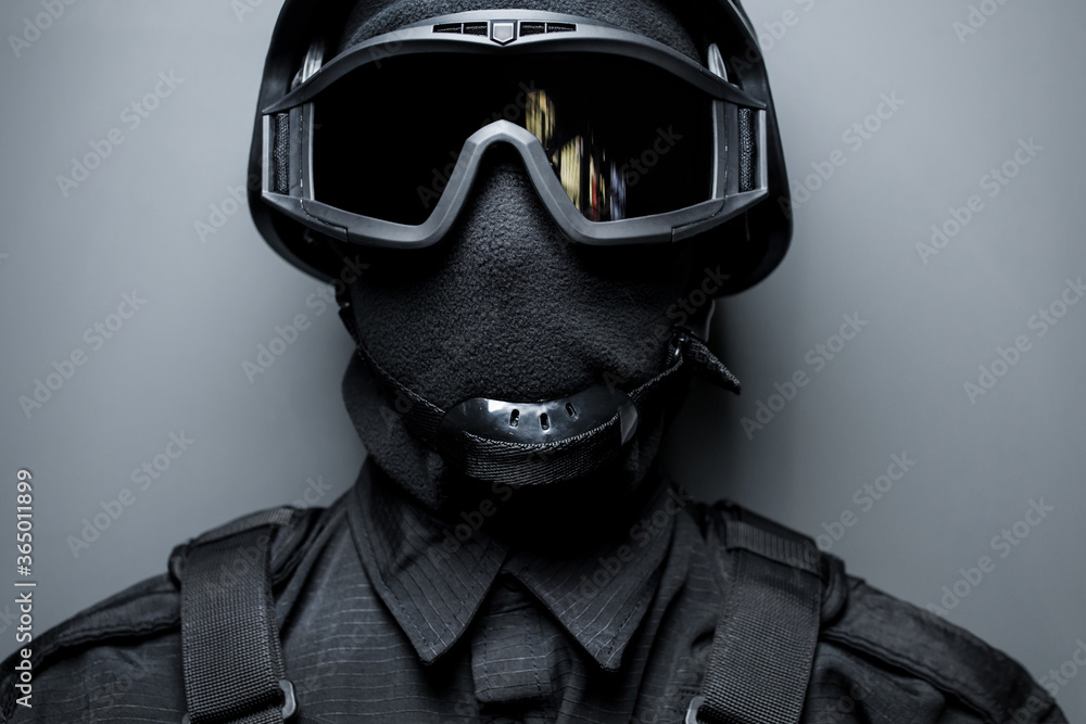 SWAT in black uniform face mask and bulletproof vest. Russian