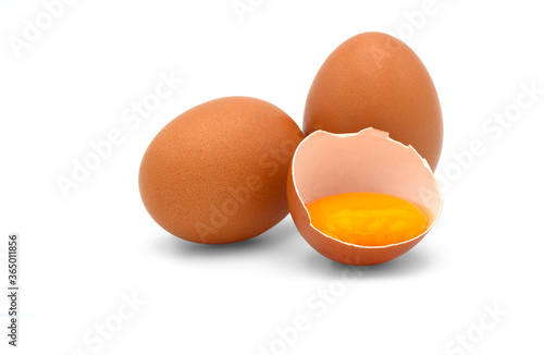 Eggs and a half of chicken egg with yolk in egg shell isolated on white background.