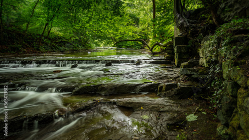 Waterfall at Holywell Dene in the county of Northumberland, England, UK. With full summer green foliage on trees.