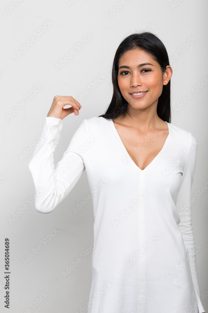 Portrait of young beautiful Asian woman against white background Portrait of young beautiful Asian woman against white background