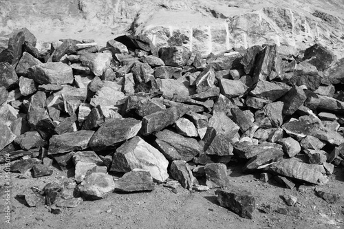 Black and White Image of Pile Of Rocks I.E. Lithium Mining And Natural Resources Like Limestone Mining In Quarry. Natural Zeolite Rocks Are Excavated With Deforestation In Background.