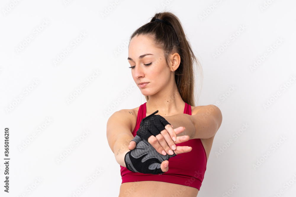 Young sport brunette woman over isolated white background stretching arm Young sport brunette woman over isolated white background stretching arm