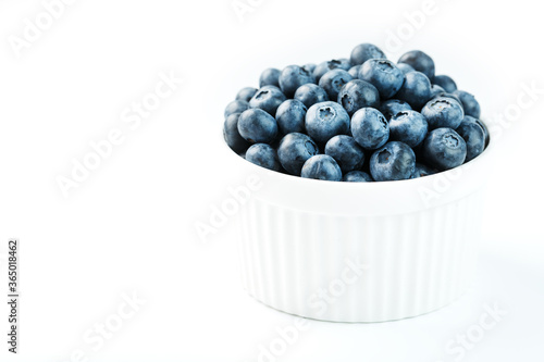 Blueberries in a white Cup on a white background. Isolate, free space