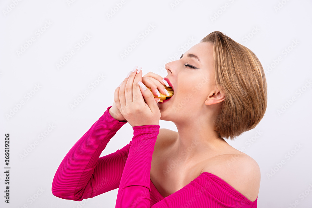 young and beautiful girl with an appetite puts fries in her mouth, hunger and great appetite, beautiful face, short haircut, hot pink clothes, burger girl young and beautiful girl with an appetite puts fries in her mouth, hunger and great appetite, beautiful face, short haircut, hot pink clothes, burger girl