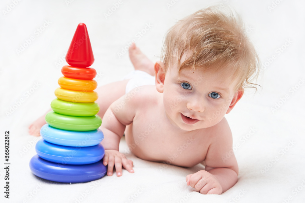 Cute baby boy with toy pyramid on light background Cute baby boy with toy pyramid on light background
