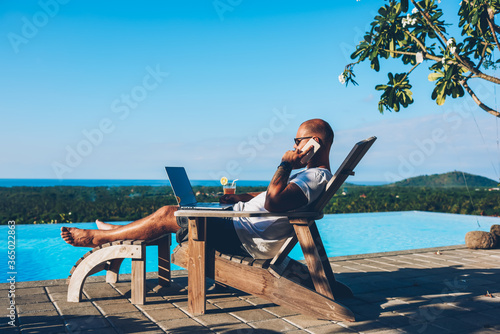 Canvastavla Young businessman resting on sunbed enjoying summertime in resort spa near swimm