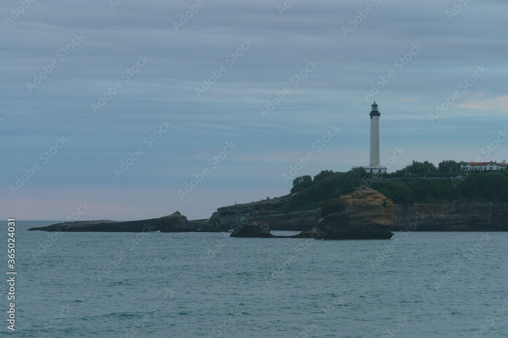 The architecture of French Biarritz. Lighthouse on the shore. Cloudy sunset. Touristic concept.