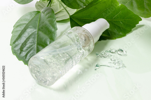 Organic cosmetics for face and body care on a white background with green leaves. Layout, copy space.