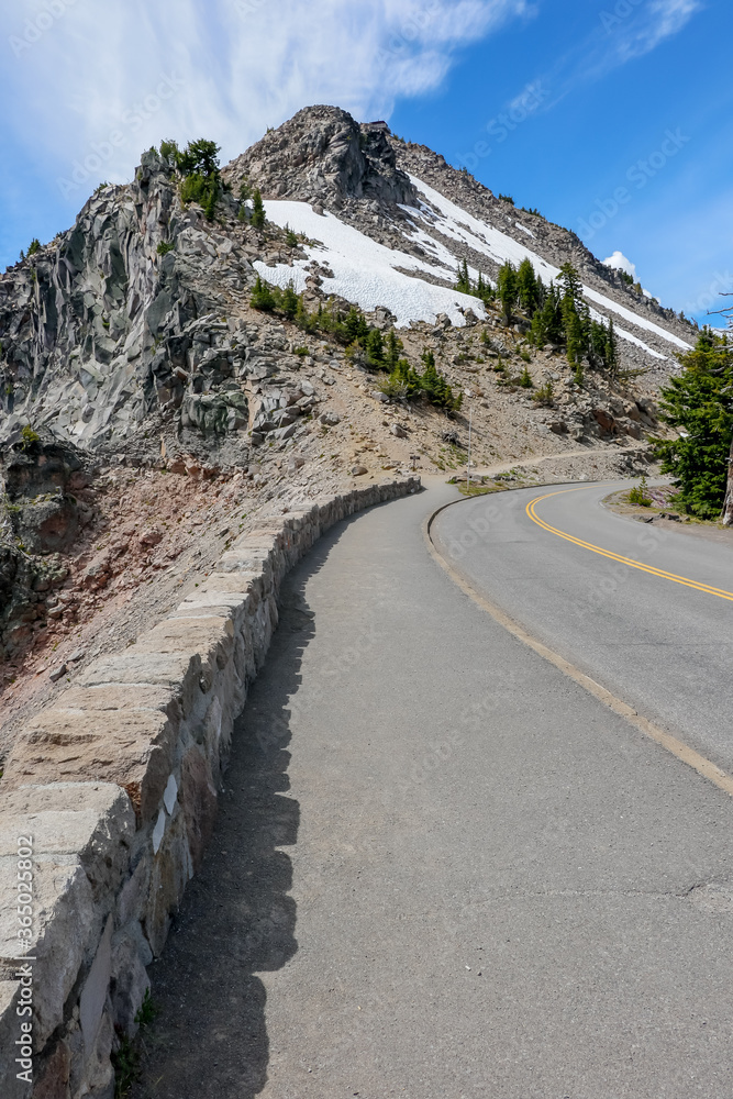 Rim Road of Crater Lake National Park with Snow on Mountain and Blue Sky in Summer at Oregon, USA