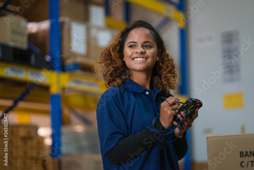 industrial worker in factory, worker woman smiling working in warehouse stock checking. happy work black girl in factory photo