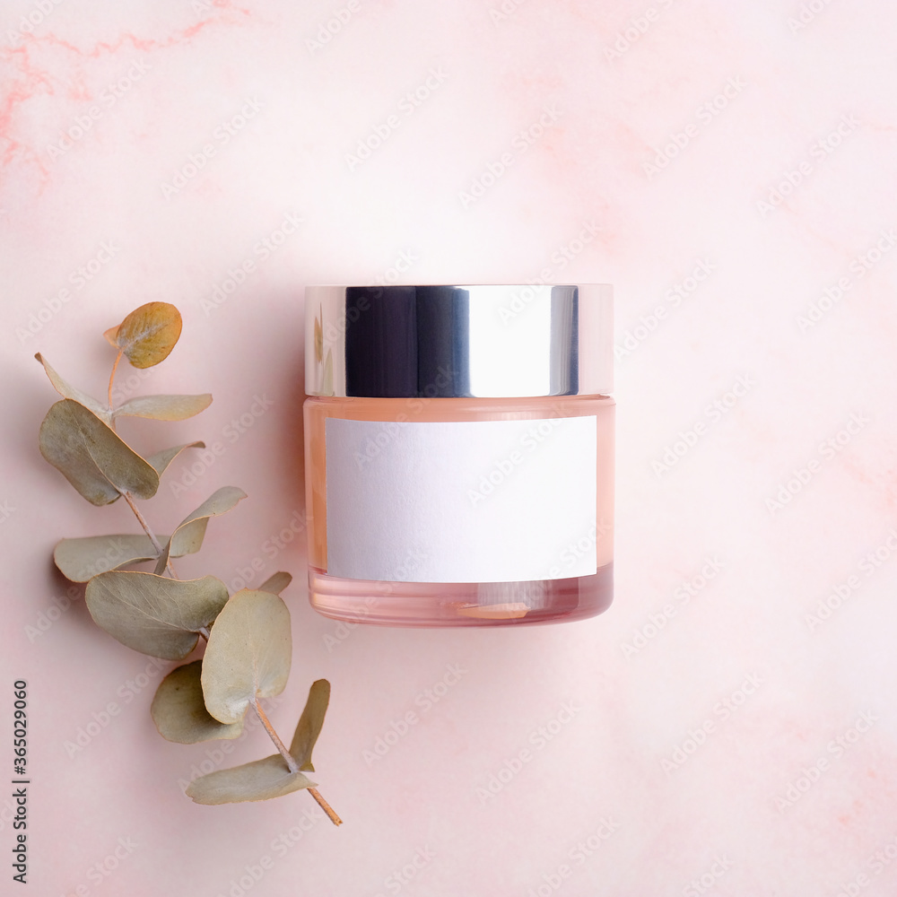 Jar with moisturizer cream and eucalyptus leaf on pink background ...