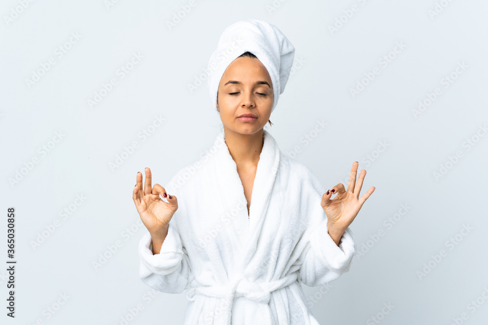 Young woman in bathrobe over isolated white background in zen pose Young woman in bathrobe over isolated white background in zen pose