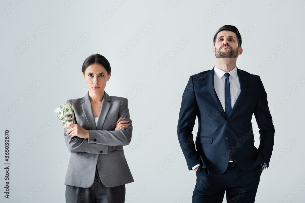 Fotografie businesswoman holding dollars near arrogant businessman standing with hands in p