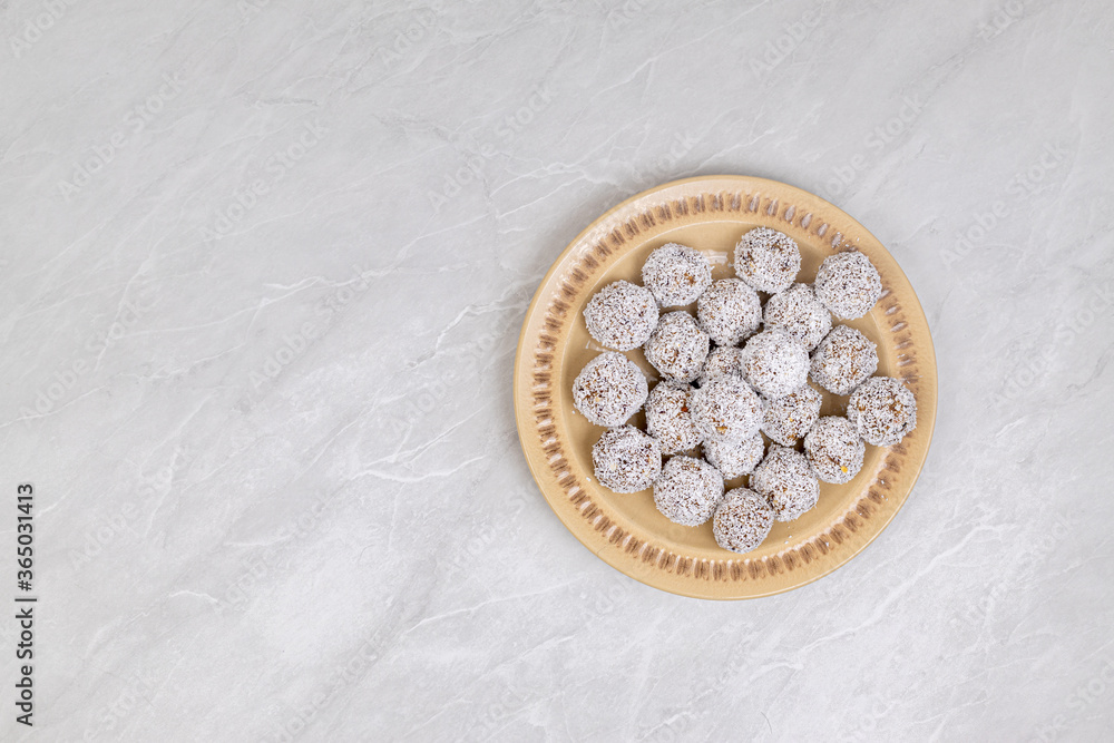 Fototapeta premium Energy Balls cookies with grated coconut served on the plate