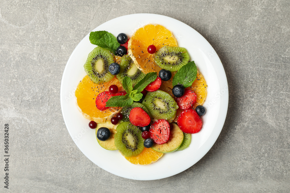 Plate of fresh fruit salad on gray background, top view Plate of fresh fruit salad on gray background, top view