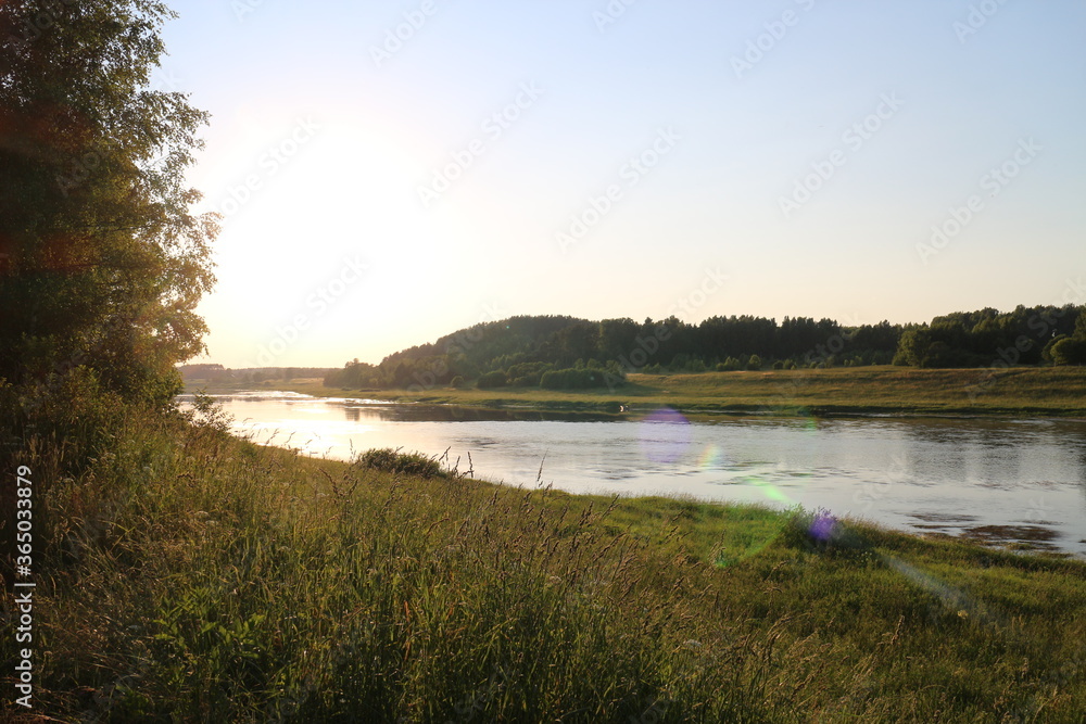 Naklejka premium Sunny evening on the river in the countryside