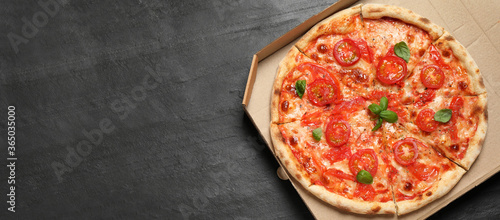 Top view of hot delicious pizza on dark grey table, space for text. Banner design