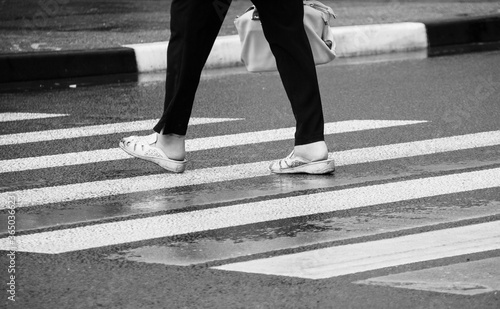 Feet on a wet street crosswalk