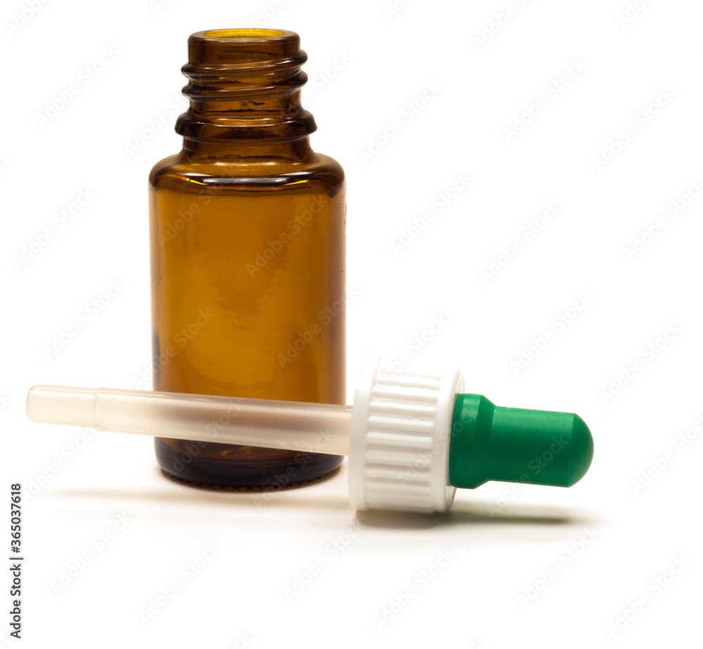 An open dark brown bottle with a pipette lying next to it on a white background. Isolated. An open dark brown bottle with a pipette lying next to it on a white background. Isolated.