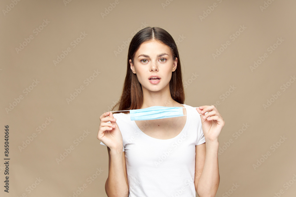 Beautiful woman medical mask protecting face beige background Beautiful woman medical mask protecting face beige background