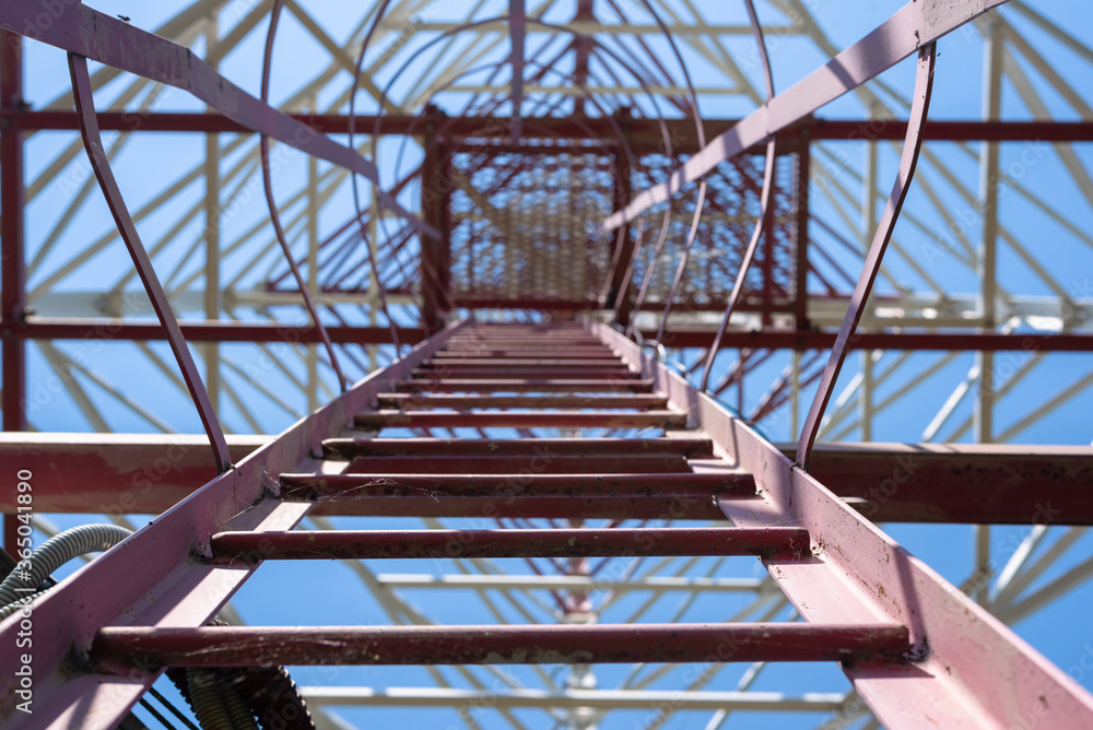 Naklejka premium Cell tower maintenance staircase on a blue sky background.
