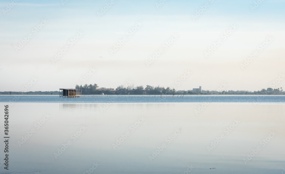 beautiful calm lake landscape at sunset with tilt house on the background beautiful calm lake landscape at sunset with tilt house on the background