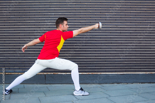 Person training fencing with a red shirt and dark background