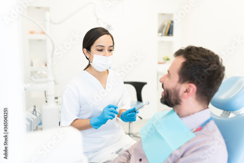 Dentist talking to patient in dental clinic