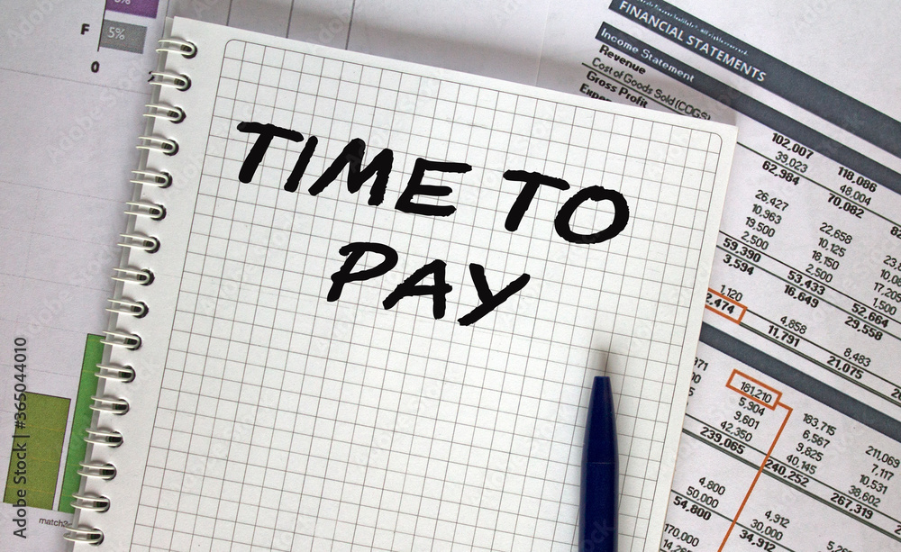 Notebook with text Time To Pay on table with pen Notebook with text Time To Pay on table with pen