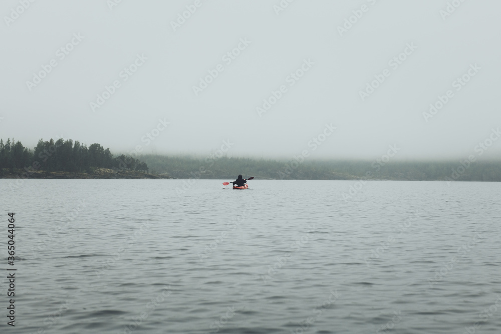 Unrecognized man in kayak. Summer trip on Ladoga lake in Karelia.