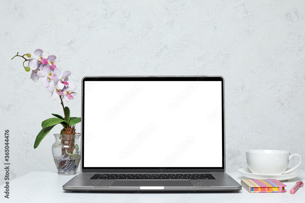 Fototapeta premium Laptop with blank empty screen on white table. feminine interior. mockup