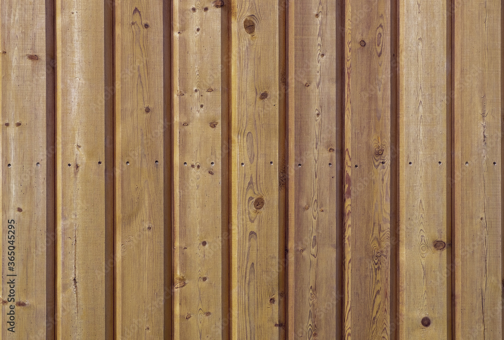 A close-up of a fragment of a wall made of vertical strug wooden planks. Horizontal orientation, front view. Selective focus. Wooden texture, background. A close-up of a fragment of a wall made of vertical strug wooden planks. Horizontal orientation, front view. Selective focus. Wooden texture, background.