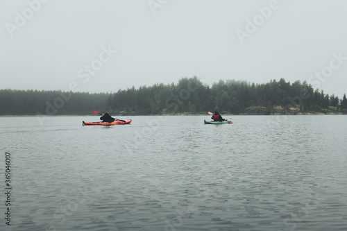 Unrecognized men in kayak. Summer trip on Ladoga lake in Karelia.