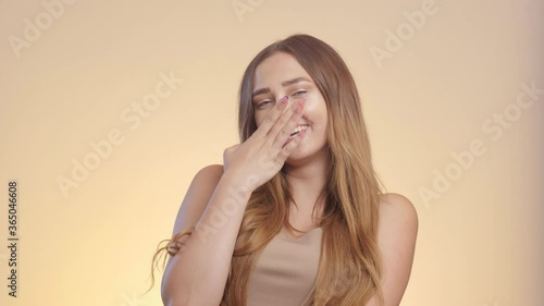 happy beautiful girl reacts on compliment and accepts it, woman embarrassed hesitated, female emotions on a studio background