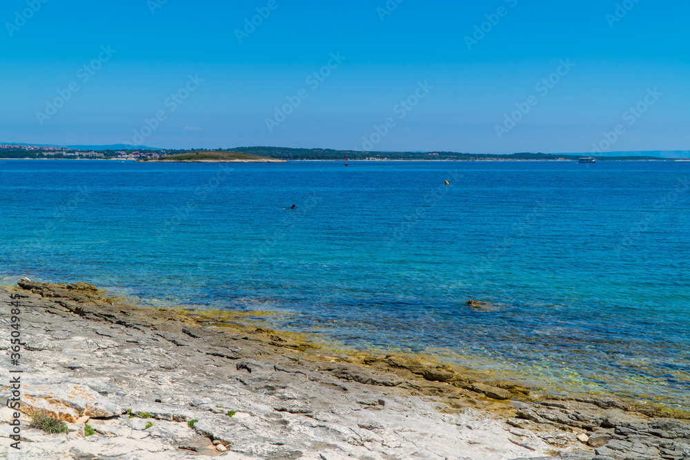 Rocky stone beach with different colors of turqouise blue waters in Kamenjak, National Park, Istria, Croatia