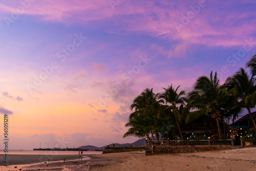 Sunset on a paradise tropical beach with palm trees.