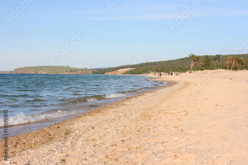 Baikal Lake. View of the shore of Olkhon Island and the coastal forest on the beach. Beautiful view of the sandy beach and lake Baikal