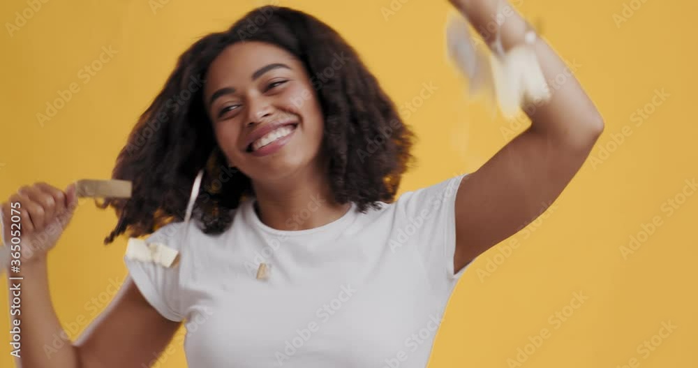 Excited african american girl dancing under rain of confetti Excited african american girl dancing under rain of confetti
