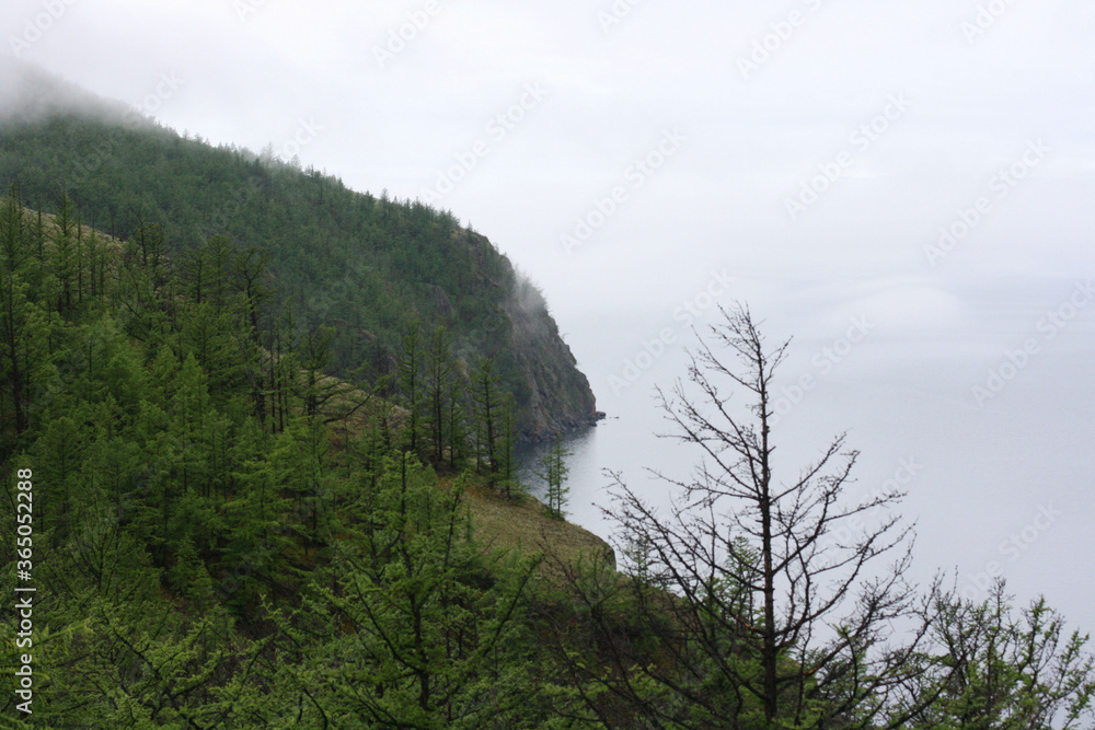 Baikal Lake in summer. View of the  Olkhon Island in rainy and foggy weather.  Lake natural background. Beautiful landscape background with copy space