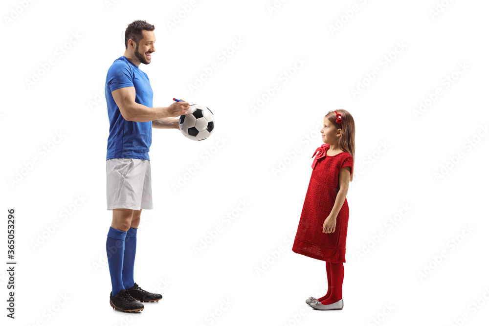 Footballer signing an autograph on a soccer ball for a little girl fan