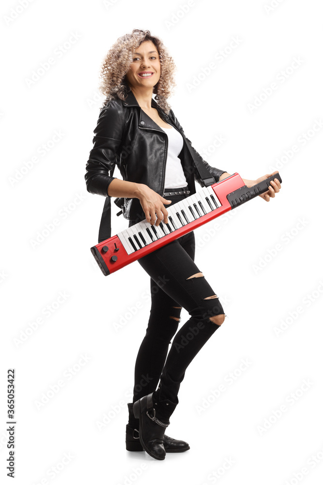 Full length portrait of a woman in leather clothing playing a keytar synthesizer