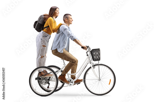 Teenage boy and girl riding on a trycicle