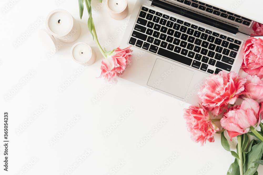 Laptop, pink peony tulip flowers on white table. Flat lay, top view minimal workspace desk. Work at home oconept Laptop, pink peony tulip flowers on white table. Flat lay, top view minimal workspace desk. Work at home oconept