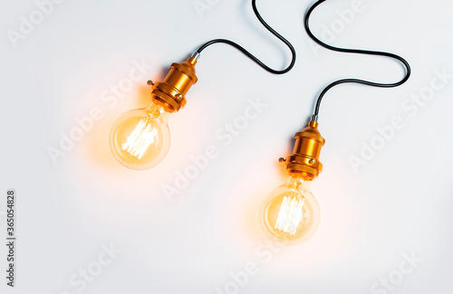 Creative idea concept, designer lamp, modern interior item. Vintage fashionable edison lamp on light gray background. Top view flat lay copy space. Lighting, electricity, background with lamp