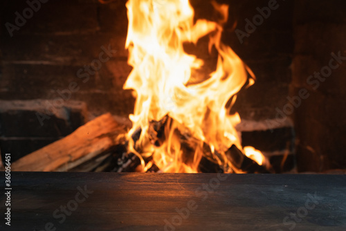 Empty table surface with copy space on burning fire background.