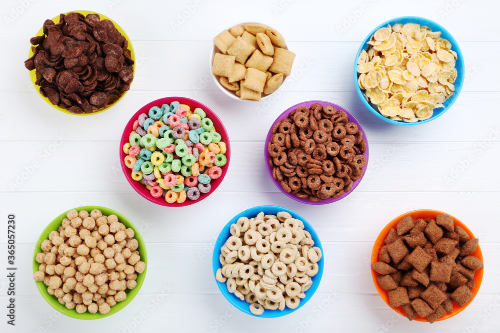 Various corn flakes in bowls on white wooden table Various corn flakes in bowls on white wooden table