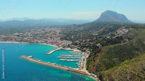 Aerial drone point of view coastal town of Javea with green mountains, turquoise bay Mediterranean Sea moored vessels in harbour, comarca of Marina Alta in province of Alicante, Valencia, Spain photo