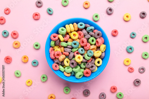 Colorful corn rings in bowl on pink background